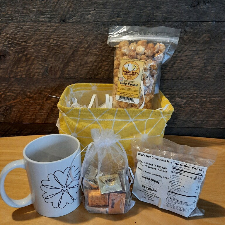 This handmade gift basket includes a choice of a ceramic mug or a stainless steel tumbler, gourmet coffee or hot cocoa mix, caramel popcorn and chocolates 