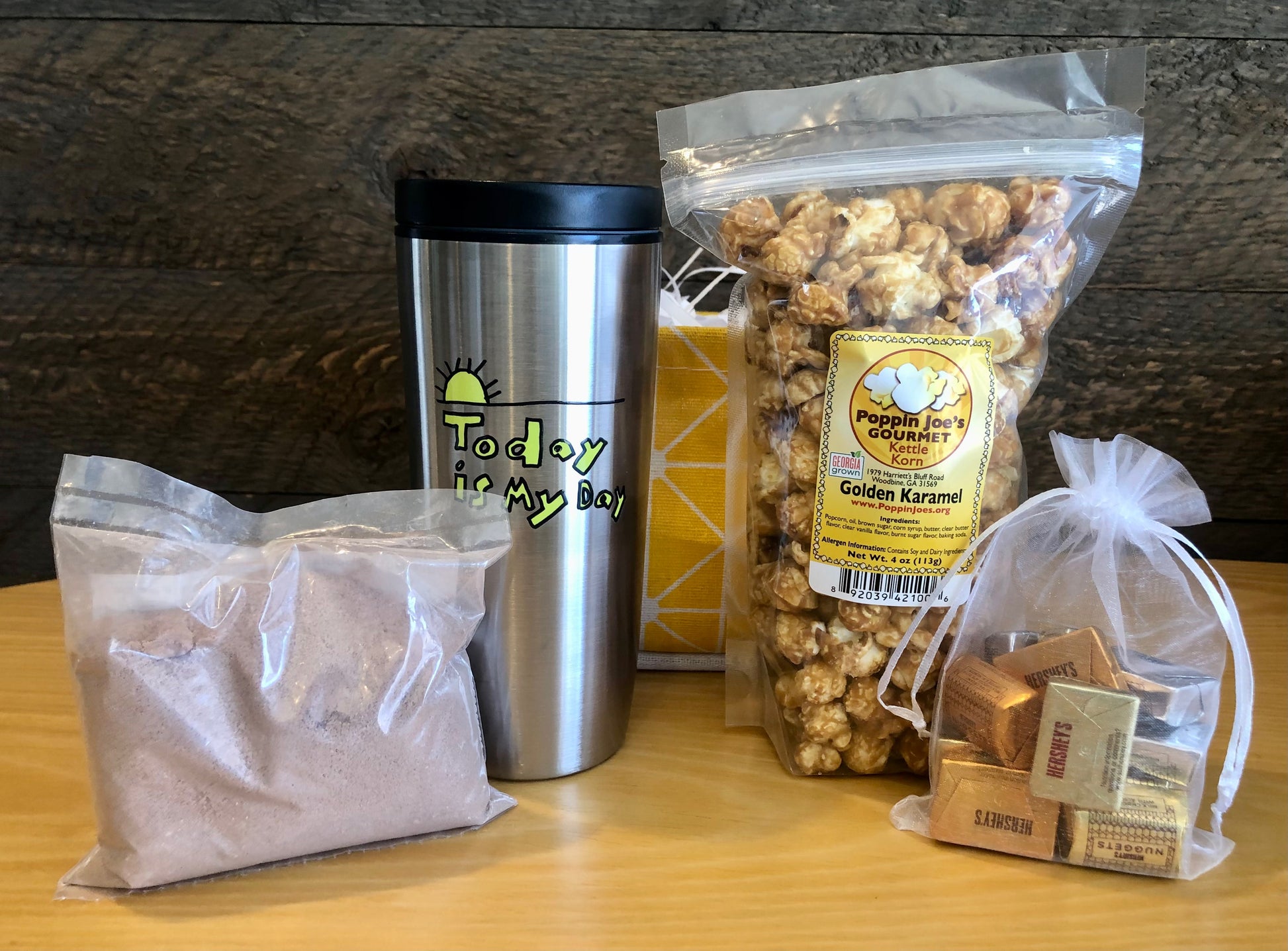 This handmade gift basket includes a choice of a ceramic mug or a stainless steel tumbler, gourmet coffee or hot cocoa mix, caramel popcorn and chocolates 