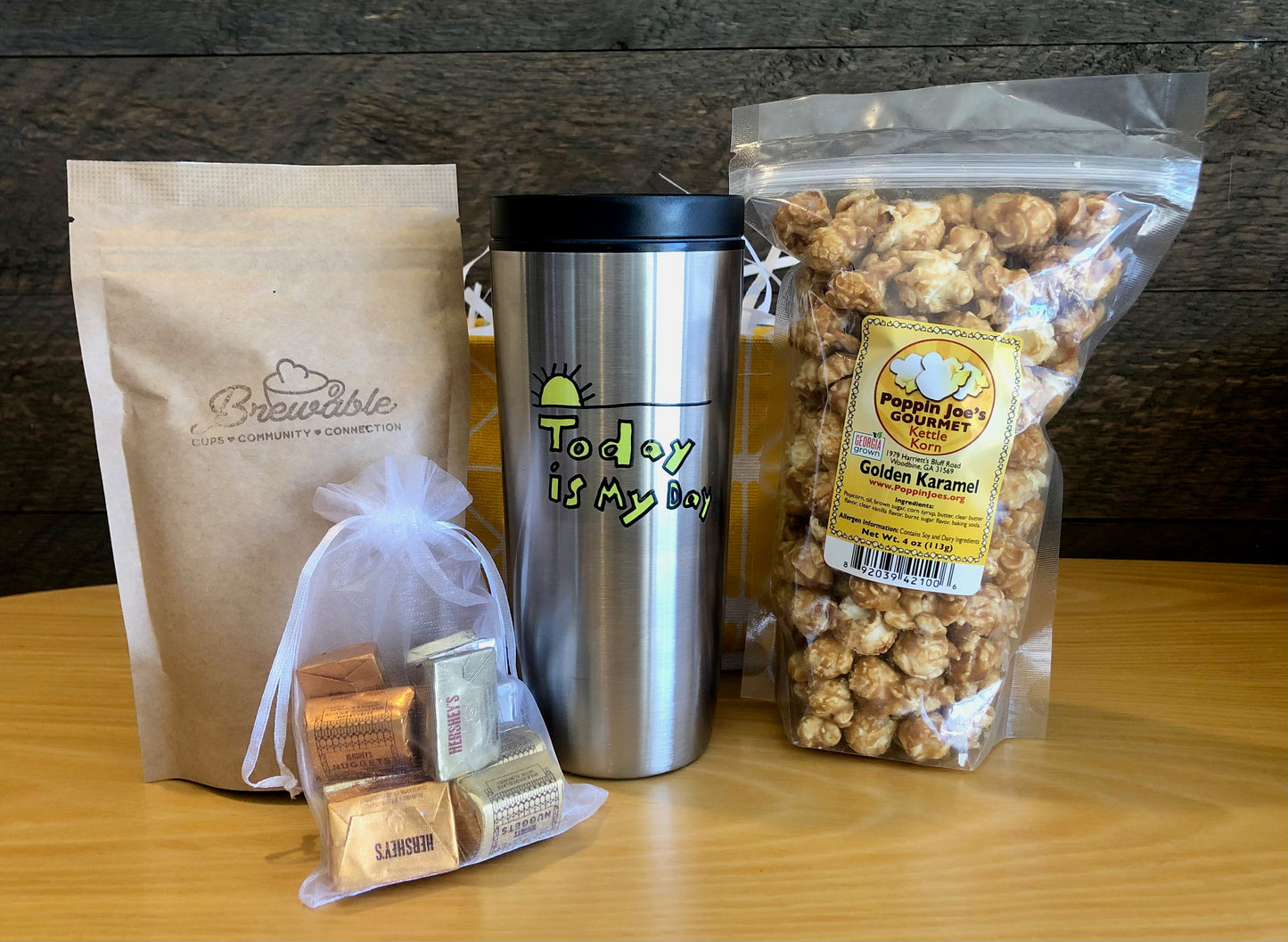 This handmade gift basket includes a choice of a ceramic mug or a stainless steel tumbler, gourmet coffee or hot cocoa mix, caramel popcorn and chocolates 