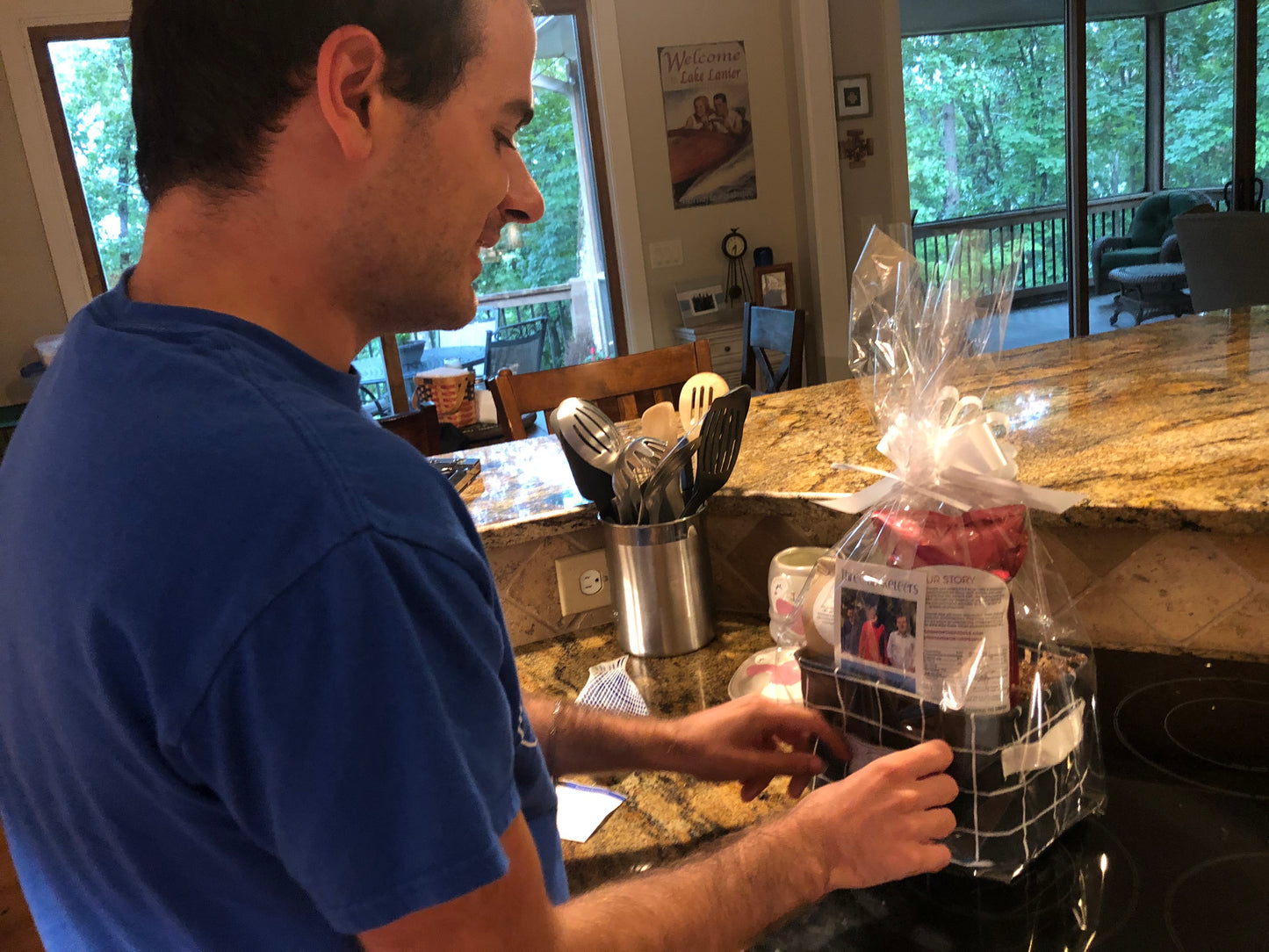 A disabled employee wrapping a "Just Because" basket in cellophane on a kitchen counter 