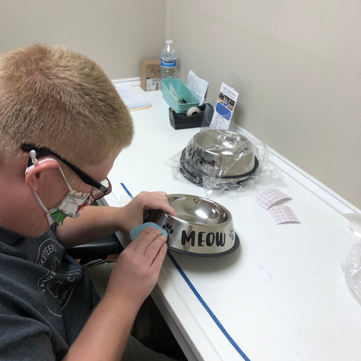 Basketeer Kyle putting pawprints and Meow on pet dish