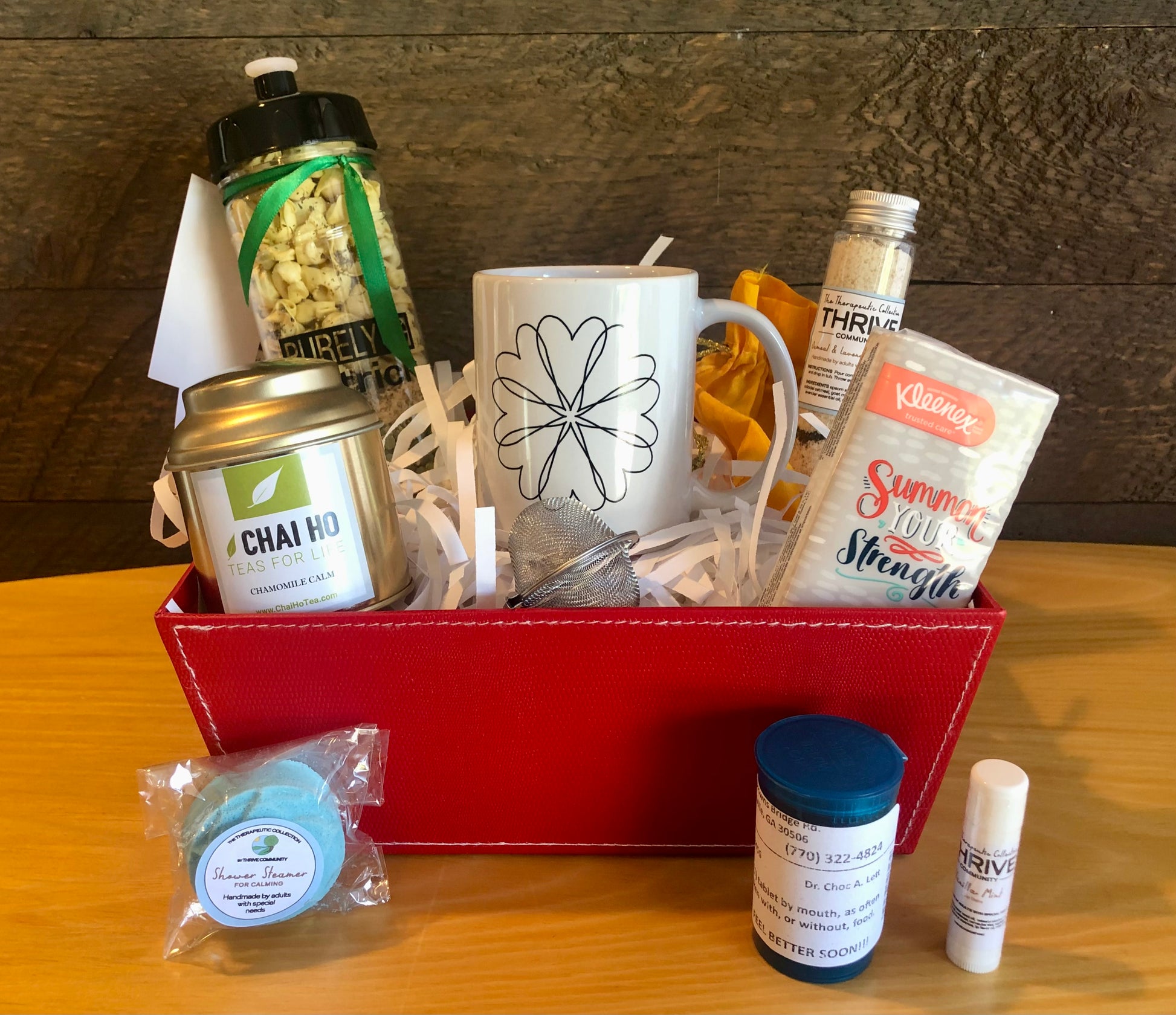 Gift basket for someone under the weather with a mug, tea, tissues,  lip balm, shower steamer, soup and chocolate treats