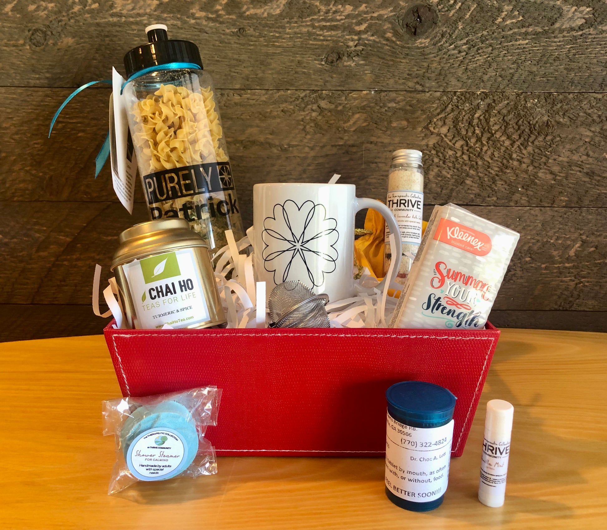 Gift basket for someone under the weather with a mug, tea, tissues,  lip balm, shower steamer, soup and chocolate treats