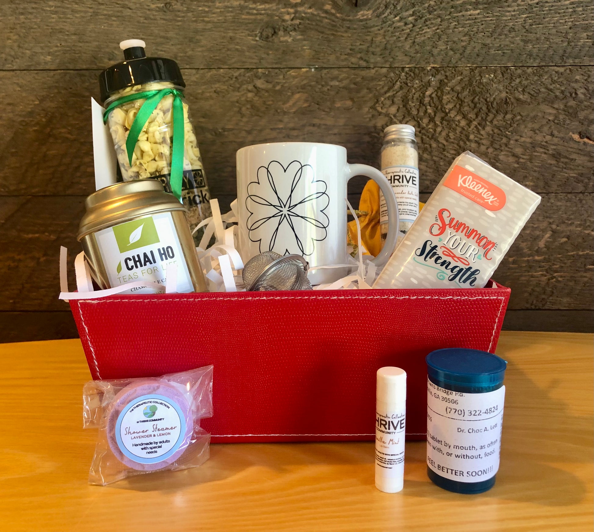 Gift basket for someone under the weather with a mug, tea, tissues,  lip balm, shower steamer, soup and chocolate treats