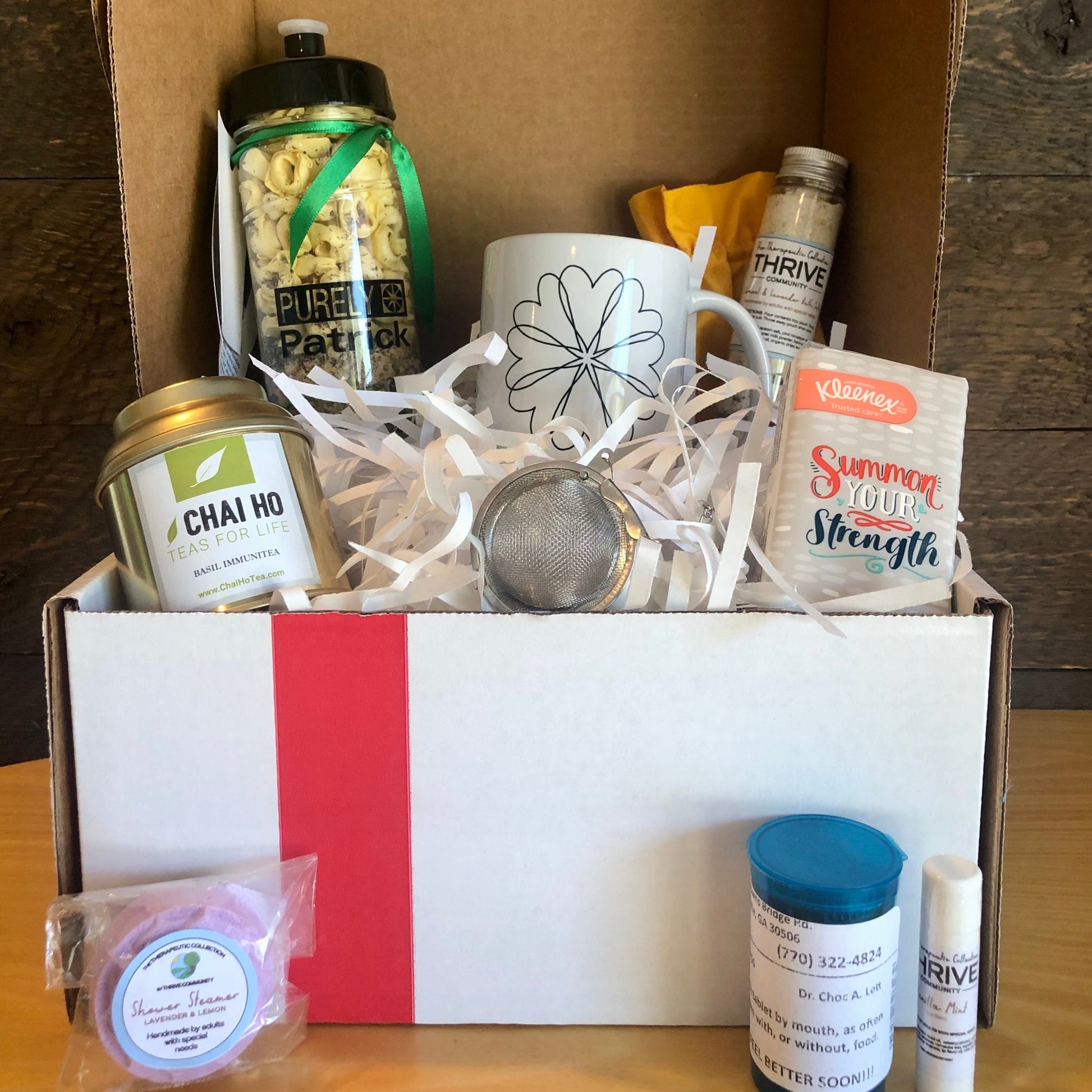 Gift basket for someone under the weather with a mug, tea, tissues,  lip balm, shower steamer, soup and chocolate treats