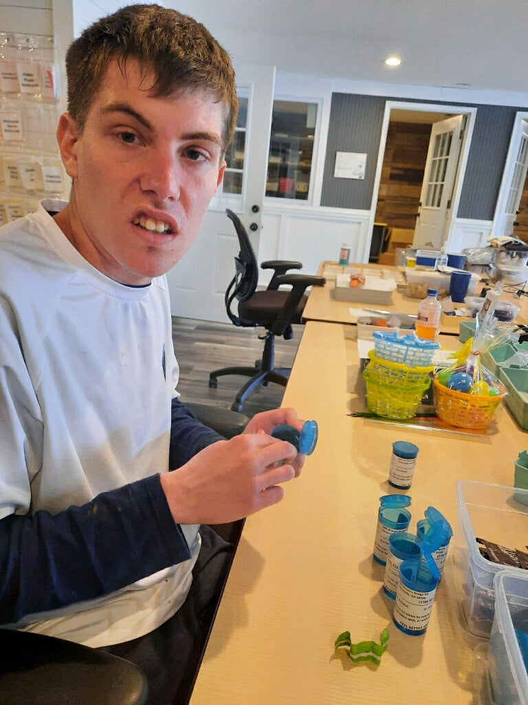 Disabled Employee Filling Chocolates for Be Well gift basket 