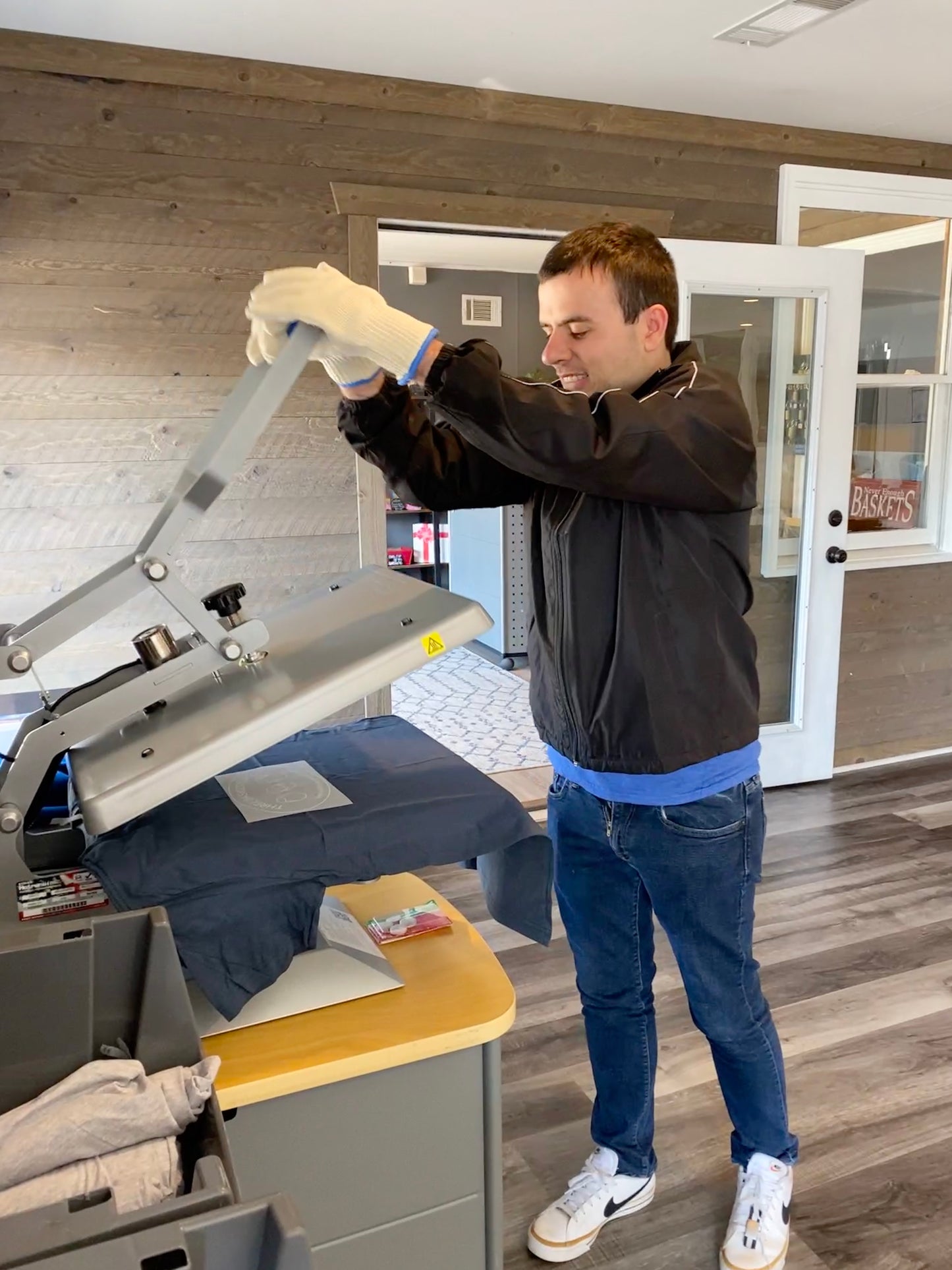 Basketeer Brett closing the heat press to make a Three Basketeers logo t-shirt