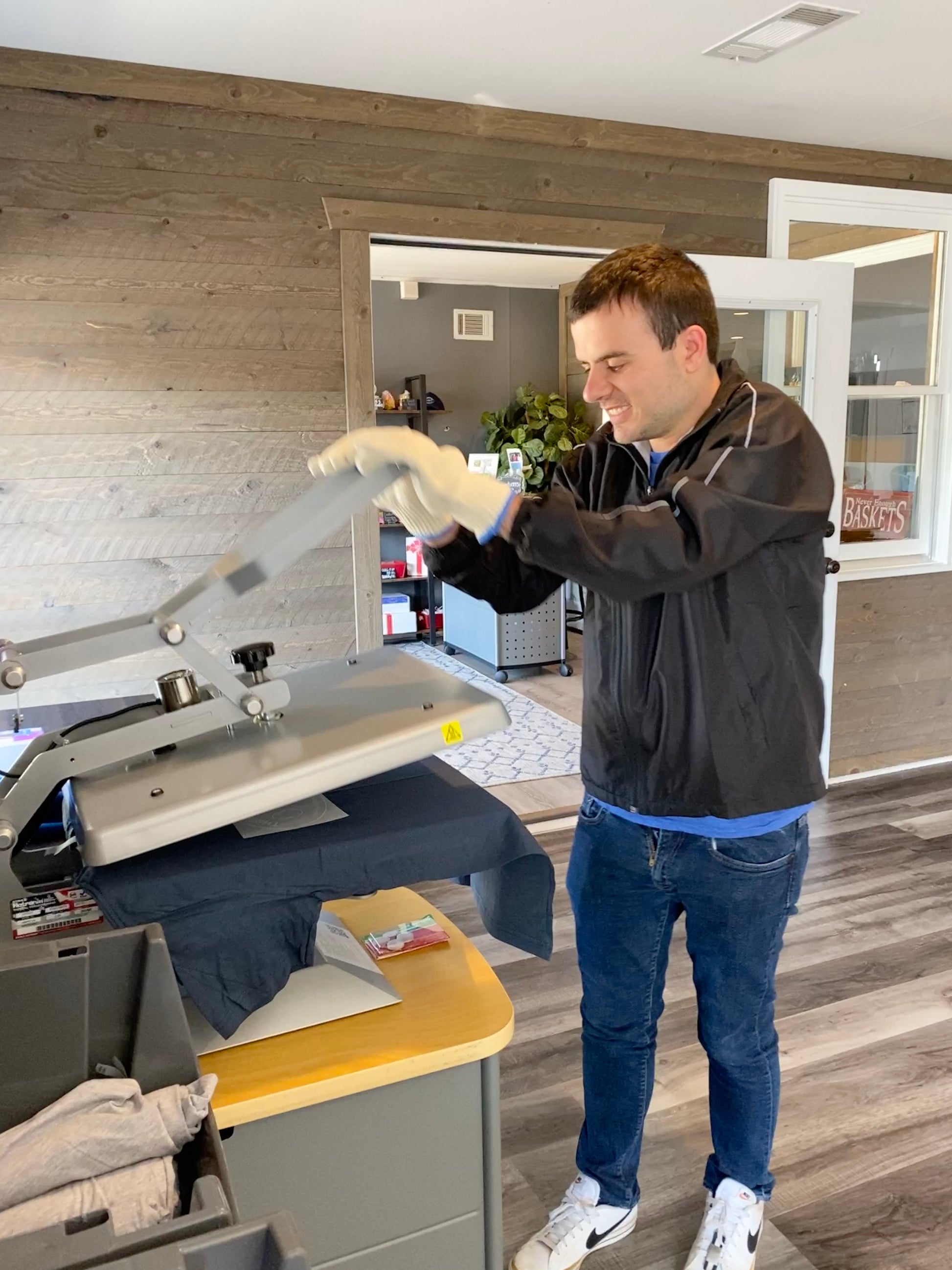 Basketeer Brett opens the heat press to create a Three Basketeers logo t-shirt