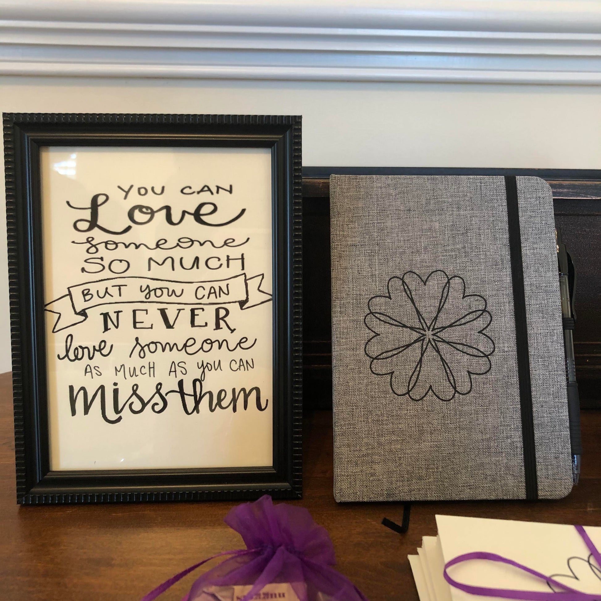 Close up of the frame calligraphy "You can love someone so much but you can never love someone as much as you miss them" and the fabric covered journal in the Grief Care condolence gift basket