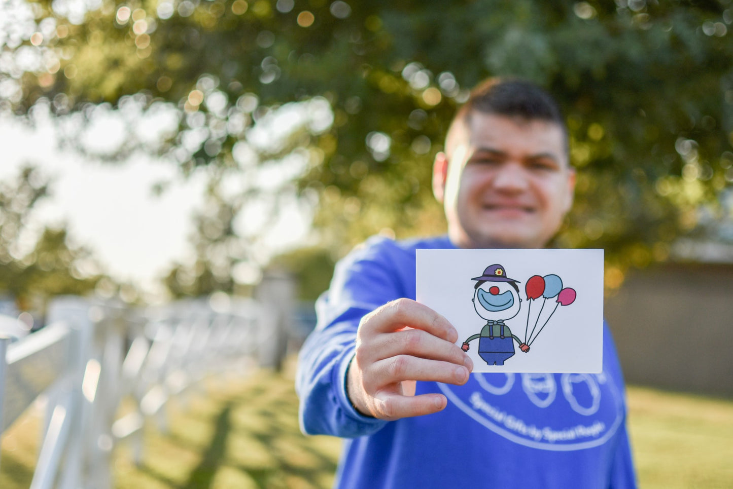 disabled business owner holding happy birthday note cards while standing outside