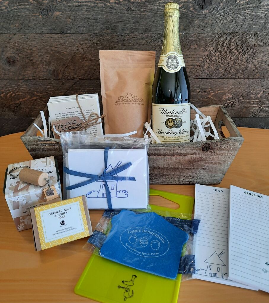 This housewarming gift basket includes gourmet coffee, sparkling juice a "Home" cork keychain, decorated cutting board, a jar opener, home themed notecards, an oak and honey double wick candle, oatmeal milk and honey scented soap bar and optional handmade coasters. 