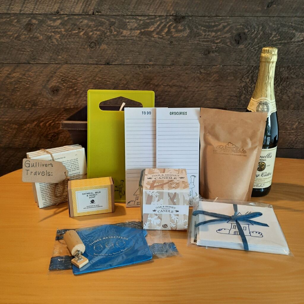 This housewarming gift basket includes gourmet coffee, sparkling juice a "Home" cork keychain, decorated cutting board, a jar opener, home themed notecards, an oak and honey double wick candle, oatmeal milk and honey scented soap bar and optional handmade coasters. 